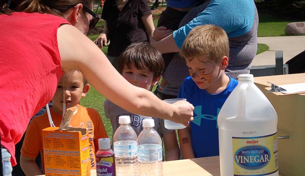 Woman helping children with science experiment
