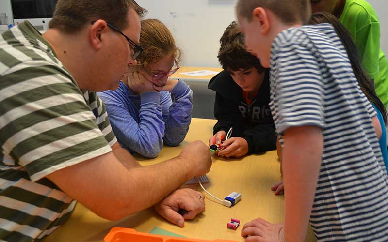 Children and adult working together on science project